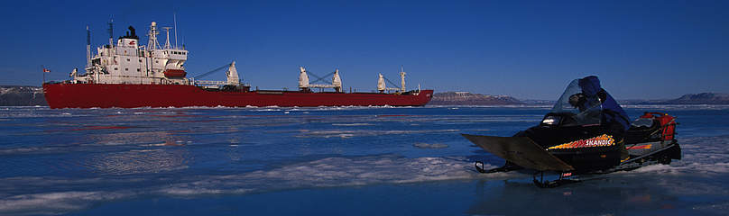 An Inuk hunter on a snowmobile observing an icebreaker ship, Admiralty Inlet, Nunavut, Canada. / ©: Paul Nicklen/National Geographic Stock / WWF-Canada / ©: Paul Nicklen/National Geographic Stock / WWF-Canada