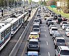 Highway traffic alongside commuter train